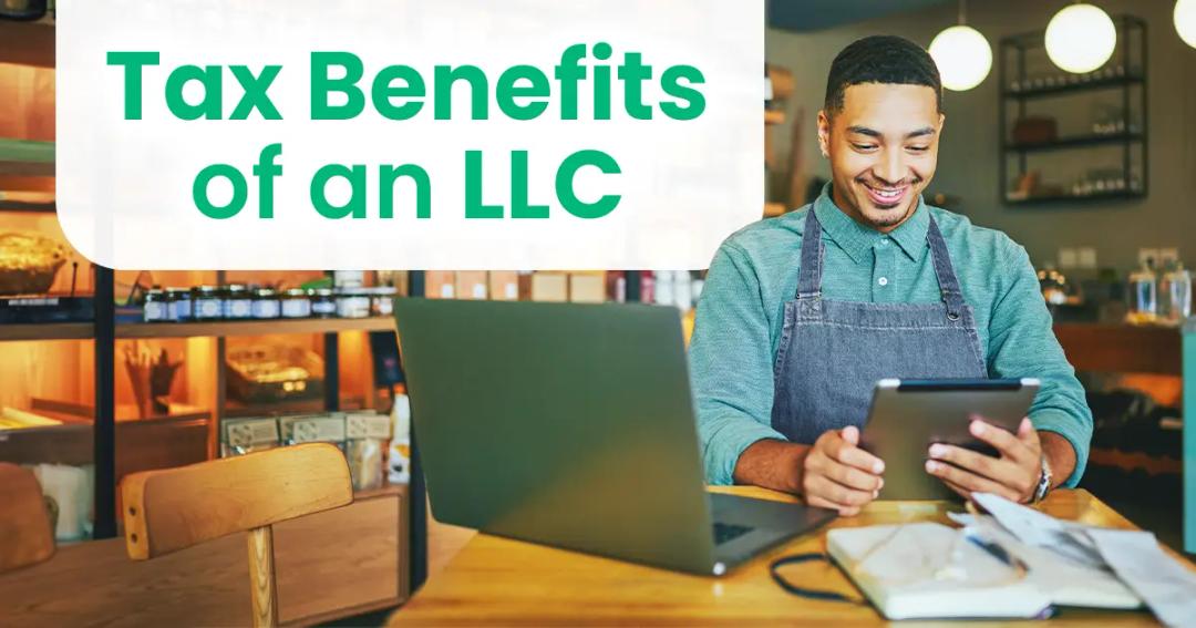 Man in an apron working on a tablet in a cafe-like setting next to a laptop with text "Tax Benefits of an LLC" displayed.